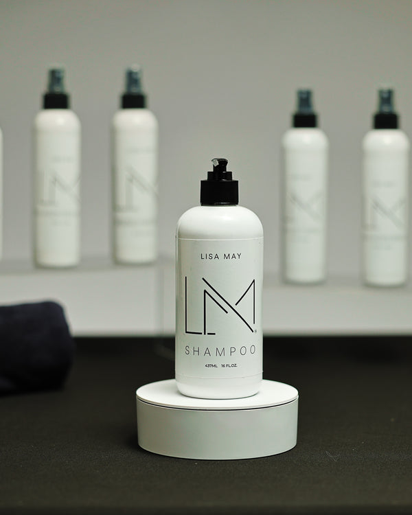 Lisa May Eco Hair Care Shampoo in a tall white bottle with a black dispenser cap