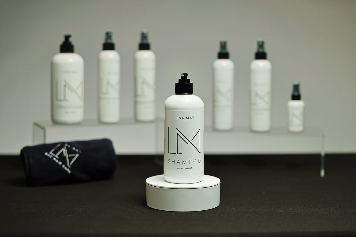 Lisa May Eco Hair Care Shampoo in a tall white bottle with a black dispenser cap