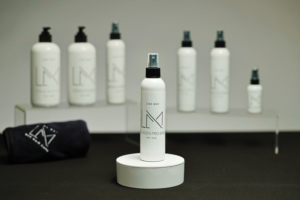 Lisa May Eco Hair Care Collagen Pro Spray in a white mist-spray bottle on a round white stand
